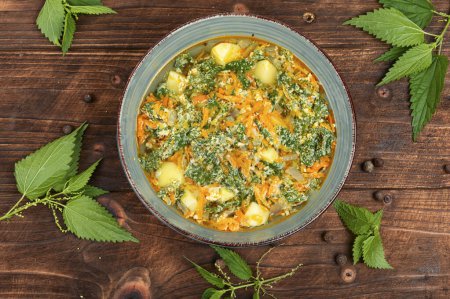 Photo for Vegan nettle soup on old rustic wooden table. Top view. - Royalty Free Image