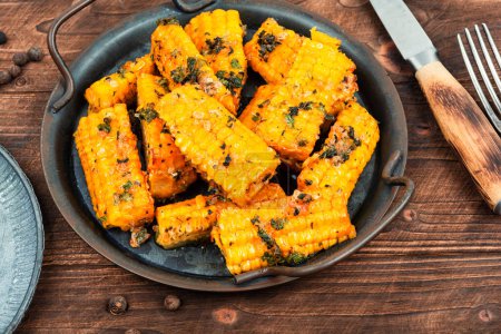 Photo for Ears of corn or maize baked with herbs. Grilled young corn from above on the rustic wooden table. Vegetarian dishes. - Royalty Free Image