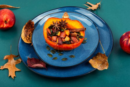 Téléchargez les photos : Citrouille d'automne mi-orange ou courge cuite aux pommes, pêches et cannelle. Recette d'automne diétique - en image libre de droit