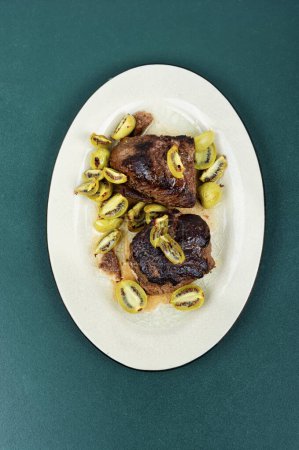 Téléchargez les photos : Steak d'autruche rôti avec mini sauce kiwi - en image libre de droit