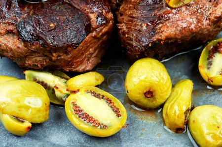 Téléchargez les photos : Steak d'autruche rôti avec mini sauce kiwi. Viande aux baies de kiwi - en image libre de droit