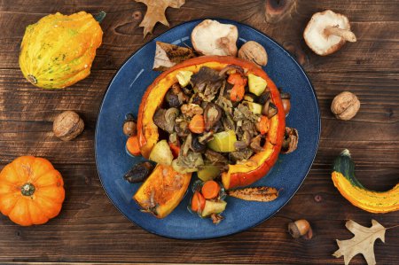 Photo for Baked whole pumpkin stuffed with beef meat, mushrooms, apple and carrots on rustic table. Top view. - Royalty Free Image