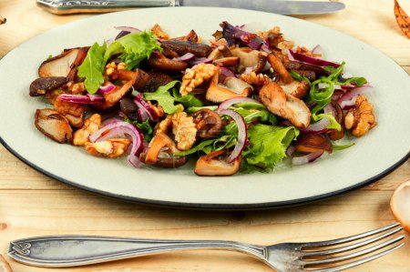 Téléchargez les photos : Salade fraîche aux champignons rôtis, oignons, laitue et noix. Alimentation végétarienne saine - en image libre de droit