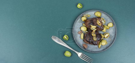 Photo for Roasted ostrich steak and mini kiwi on a plate - Royalty Free Image