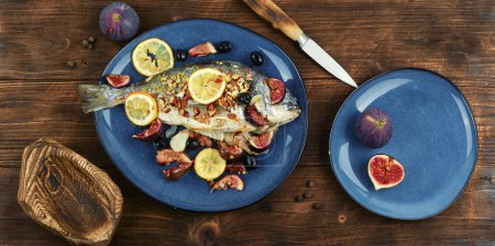 Photo for Baked gilt head bream, dorado fish with almonds and figs on rural wooden table. Autumn recipe. - Royalty Free Image