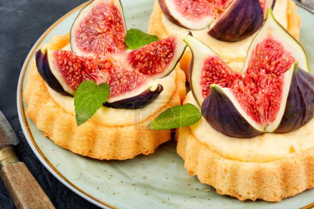 Téléchargez les photos : Mini gâteaux acidulés ou tartelette dessert à la crème fouettée et figues. Gros plan. - en image libre de droit