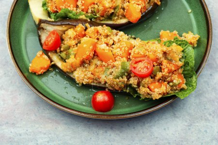 Téléchargez les photos : Aubergines farcies à la citrouille, tomates et quinoa dans une assiette. - en image libre de droit