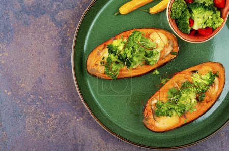 Téléchargez les photos : Plat végétarien, patate douce cuite au four farcie de champignons, brocoli et poivrons. Espace de copie. - en image libre de droit