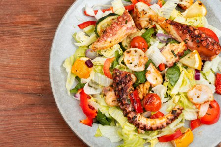 Téléchargez les photos : Salade de légumes frais et de pieuvres tentacules et calmars sur assiette. Espace de copie - en image libre de droit