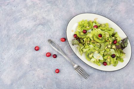 Téléchargez les photos : Salade végétarienne de kiwi, laitue, baies et pignons. Régime alimentaire Keto. Espace de copie - en image libre de droit