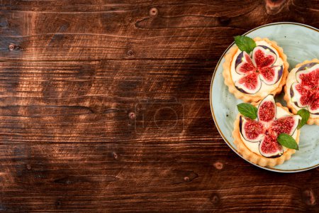 Photo for Tartlets with cream and figs on a light plate. Sweet tartlets with fresh berries. Copy space. - Royalty Free Image