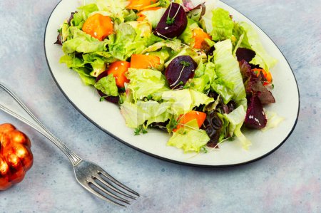 Photo for Seasonal autumn vegetable salad of roasted pumpkin, beets and greens. Green vegan salad. - Royalty Free Image