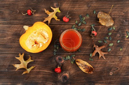 Photo for Delicious pumpkin jam in a glass jar and fresh pumpkins on rustic wooden table. - Royalty Free Image