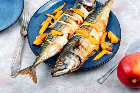 Photo for Appetizing mackerel fish baked with mango slices, dieting. Seafood. - Royalty Free Image