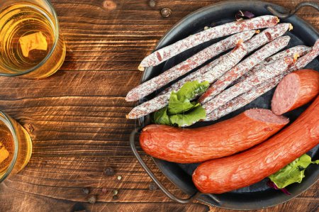 Photo for Kabanos sausages,smoked salami sausage. Dry smoked sausages, salami, kabanos and cold beer on a rustic table. Appetizing beer snacks. - Royalty Free Image