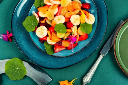 Photo for Vitamin fruit salad with banana, strawberries, grapes and nasturtium - Royalty Free Image