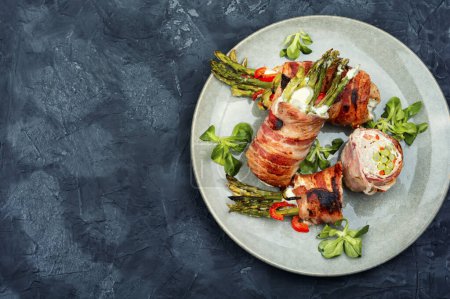 Photo for Meatloaf wrapped in bacon. Meat stuffed with asparagus and cream cheese. Space for text. - Royalty Free Image