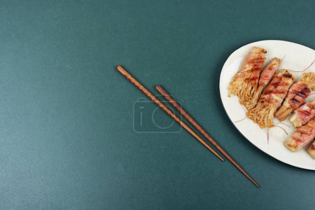 Photo for Bacon rolls stuffed with enoki mushroom. Bacon wrapped mushroom. Flat lay with copy space. - Royalty Free Image