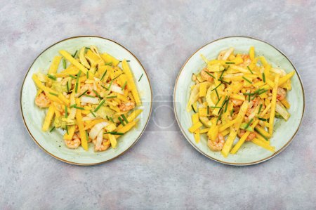 Téléchargez les photos : Délicieuse salade de mangue, avocat, crevettes grillées et pignons de pin. - en image libre de droit