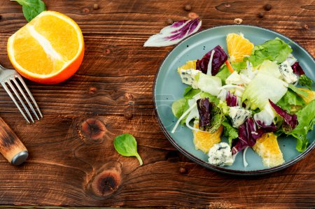 Foto de Ensalada verde con verduras, naranja y queso sobre fondo rústico. Dieta Keto o paleo - Imagen libre de derechos