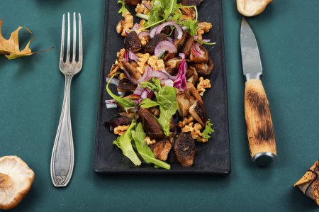 Photo for Vegetable salad with grilled forest mushrooms, onions, herbs and walnuts on plate. - Royalty Free Image