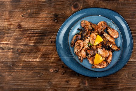 Téléchargez les photos : Crevettes grillées ou crevettes, fruits de mer. Crevettes non décortiquées rôties sur une assiette. Espace de copie. - en image libre de droit