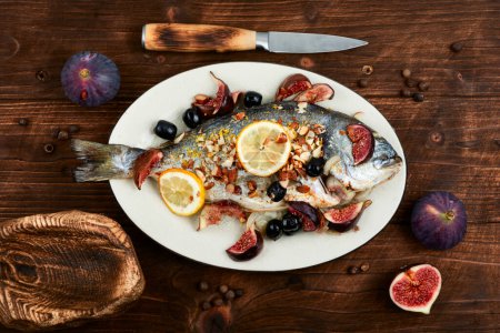Photo for Baked dorado fish with almonds and figs. Autumn recipe grilled fish. Top view. - Royalty Free Image