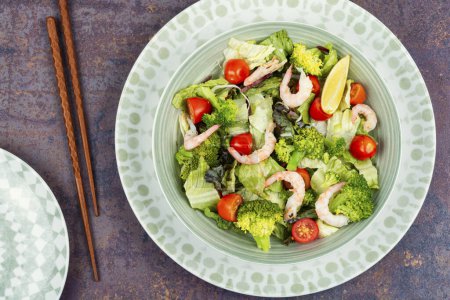 Photo for Healthy broccoli salad with shrimp, tomatoes and greens. Top view. - Royalty Free Image