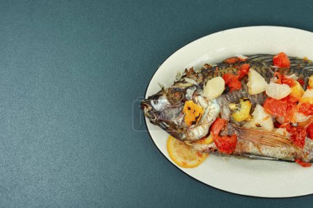 Foto de Delicioso pescado de tilapia frito con salsa de frutas en plato blanco. Piso con espacio de copia. - Imagen libre de derechos