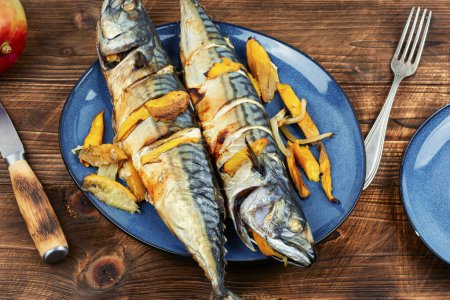 Photo for Appetizing mackerel fish baked with mango slices. - Royalty Free Image