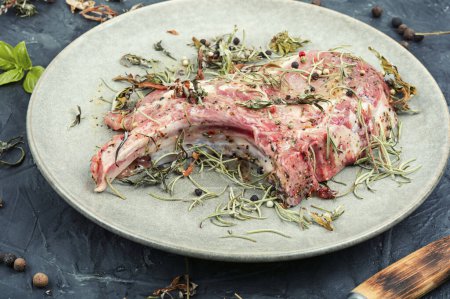 Téléchargez les photos : Bifteck de porc cru Tomahawk mariné aux herbes épicées sur fond de pierre - en image libre de droit
