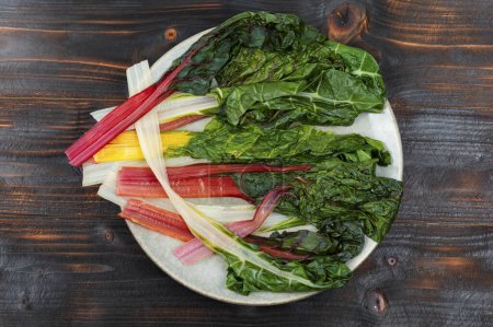 Foto de Deliciosas hojas de acelgas guisadas saludables en un plato. Desayuno saludable, vista superior - Imagen libre de derechos