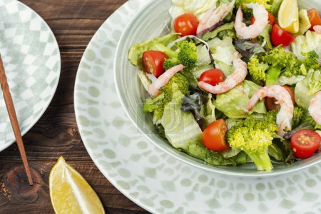 Photo for Healthy broccoli salad with shrimp, cherry tomatoes and lettuce. - Royalty Free Image