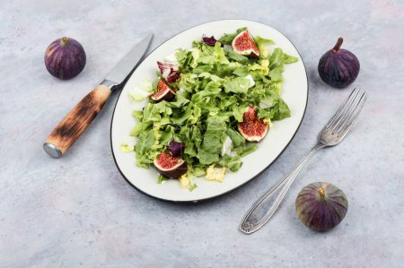 Photo for Dietetic tasty salad of greens, ripe figs and diet cheese - Royalty Free Image