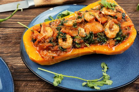 Photo for Half a butternut squash stuffed with vegetables and shrimp on wooden table. - Royalty Free Image