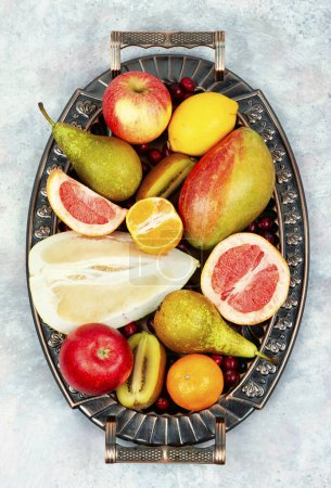 Téléchargez les photos : Ensemble de fruits exotiques et variés sur plateau vintage. Pose plate. - en image libre de droit