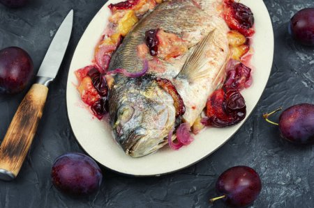Photo for Dorado or sea bream fish baked with plums. - Royalty Free Image
