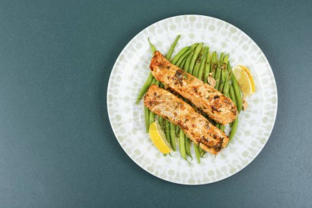 Téléchargez les photos : Filet de saumon frit avec haricots verts et citron vert dans l'assiette. Dîner cétogène. Espace de copie. - en image libre de droit