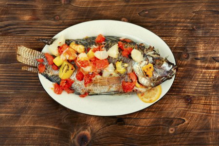 Téléchargez les photos : Délicieux poisson tilapia frit avec sauce aux fruits dans une assiette blanche. Poisson Pla Pao Kluer. - en image libre de droit