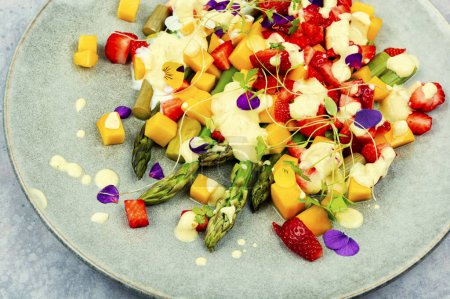 Foto de Ensalada deliciosa y saludable con especias, fresas, yogur y mango en el plato. - Imagen libre de derechos