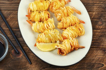 Téléchargez les photos : Crevettes enveloppées dans des pommes de terre, des crevettes et des rouleaux de pommes de terre. Alimentation asiatique. - en image libre de droit