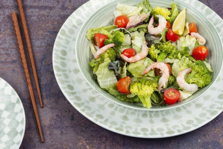 Photo for Broccoli Asian salad with prawn, tomatoes and mixed greens. Healthy food. - Royalty Free Image