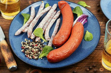 Photo for Tasty smoked kabanos sausages, salami sticks prepared from mixed minced meat with spices and beer. Bar or pub. - Royalty Free Image