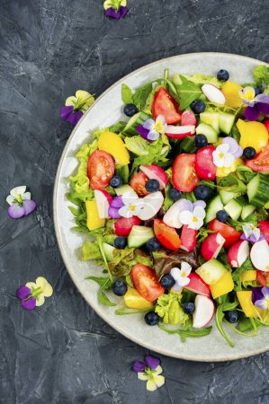 Photo for Spring salad of fresh vegetables decorated with edible flowers. - Royalty Free Image
