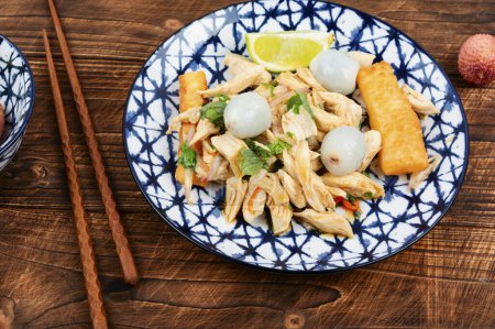 Téléchargez les photos : Salade exotique avec litchi pelé et poitrine de poulet. Nourriture asiatique sur table en bois. - en image libre de droit