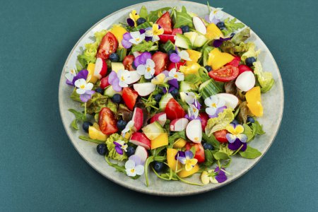 Foto de Placa de ensalada de verano de verduras frescas decoradas con flores comestibles. - Imagen libre de derechos
