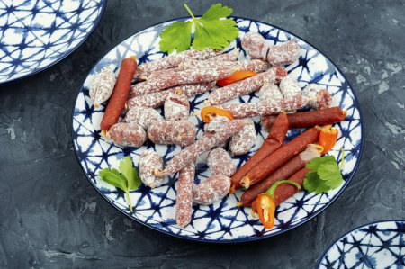 Téléchargez les photos : Salami fumé traditionnel dans une assiette, hors-d'œuvre de viande. - en image libre de droit