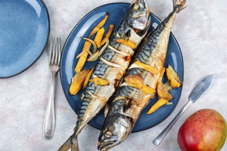 Photo for Delicious mackerel fish baked with mango slices. Seafood. Top view. - Royalty Free Image