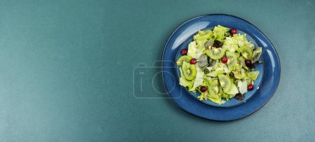 Photo for Salad of kiwi, lettuce, berries and pine nuts. Keto diet. Copy space - Royalty Free Image