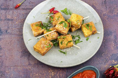 Photo for Skewers with roasted soy cheese tofu on the plate. Vegetarian grilling. - Royalty Free Image